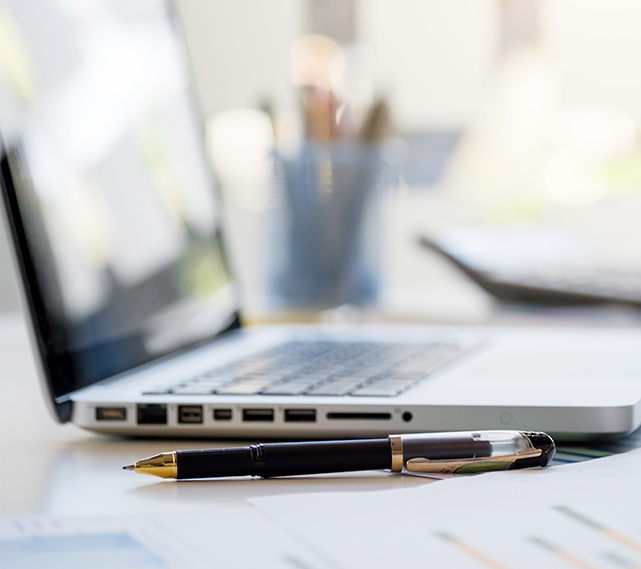 Photo of a Laptop with Pen Laying next to it